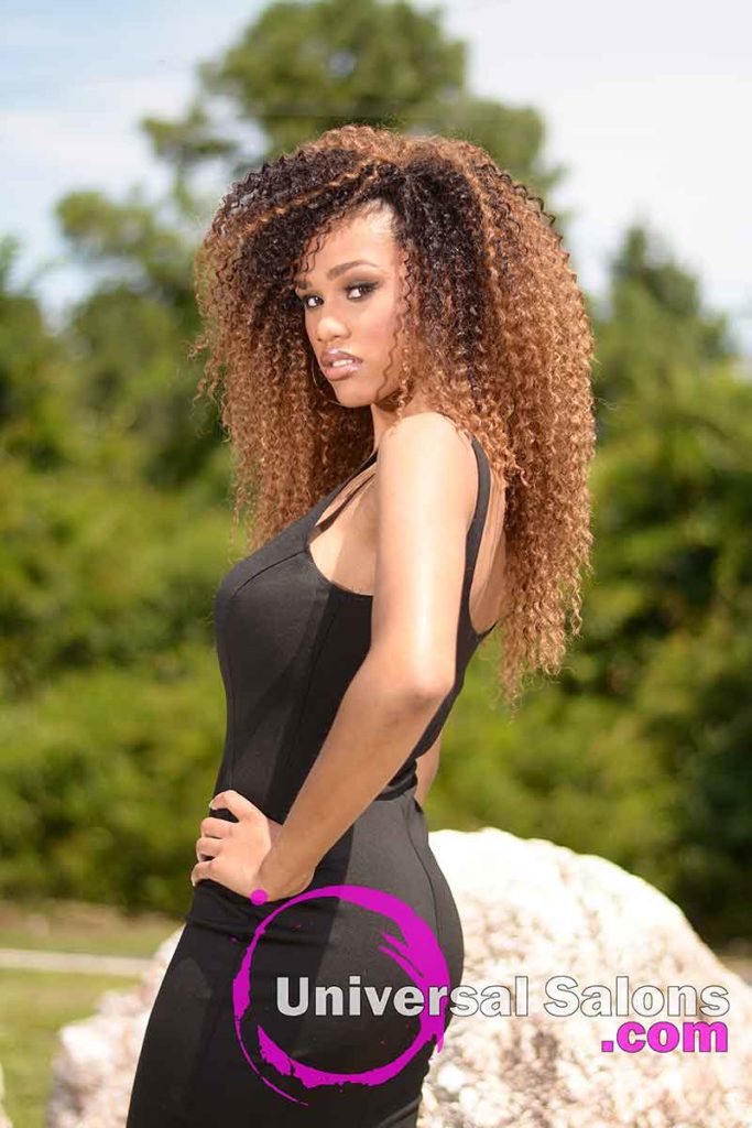Model Standing With Long Curly Sew In Hairstyle